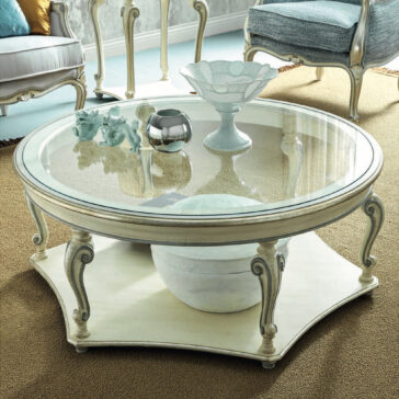 Rococo Style Round Glass Coffee Table The Rococo Style Round Glass Coffee Table enhances the room with its intricate legs, adorned on top with decorative pieces such as a ceramic bowl, black vase, and figurine. On the lower shelf, a striking marble ball catches the eye. This sophisticated arrangement is finished off with stylish chairs and a plush carpet.