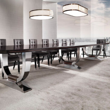 A contemporary conference room showcases a long, glossy table that evokes the design of the Large 6 Metre Italian Dining Table, flanked by cushioned chairs. Two sizable rectangular ceiling lights offer illumination, and floor-to-ceiling windows present a sweeping city view over a neutral-toned carpet.