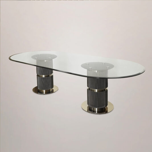 The Contemporary Oval Glass Dining Table features a sleek design with an oval top supported by two cylindrical bases, showcasing vertical black and chrome accents. The bases are set on round, flat metal bottoms, against a plain, light-colored surface.