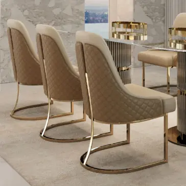 Modern Two-Tone Dining Chair Three Modern Two-Tone Dining Chairs in elegant beige and brown with quilted backs and gold legs surround a table with gold accents. They sit on a light carpet, against marble walls, framing a window showcasing a stunning city view.