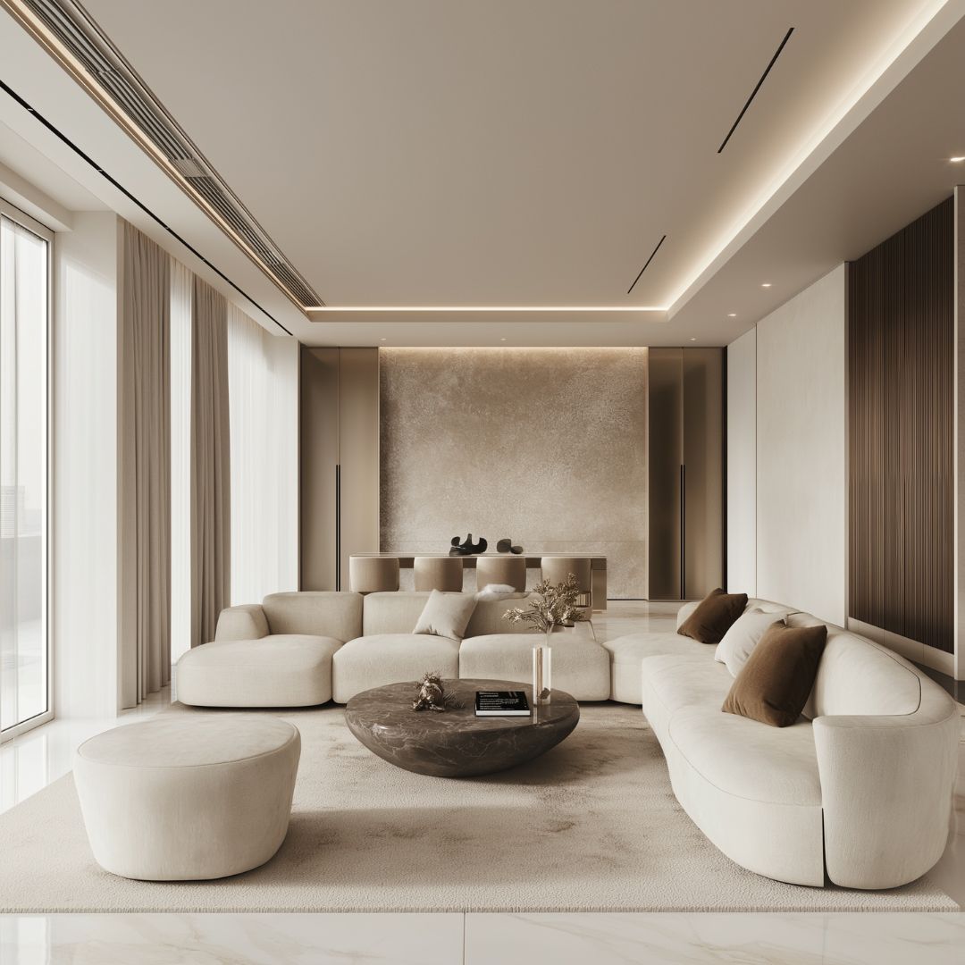 A modern, minimalist living room with neutral tones features curved white sofas and a round stone coffee table. Floor-to-ceiling windows flood the space with natural light, highlighting the textured wall and sleek decor, subtly embracing colour theory for a harmonious ambience.