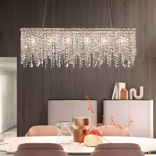 A dining room features a Contemporary Rectangular Cut Crystal Chandelier above a sleek white table adorned with glass vases and a decorative red branch, encircled by pink chairs. A gray cabinet complements the dark wood wall, enhancing the modern vibe.