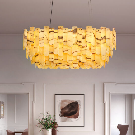 A Contemporary Rectangular Cut Crystal Chandelier of layered amber glass hangs from the ceiling. Below, a minimalist room features framed abstract art and a small vase with greenery on a table.