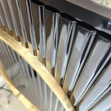 Luxury Art Deco Style Sunburst Sideboard Close-up of shiny metal bars in a curved wooden frame, reflecting light and mirroring the refined, modern look of the Luxury Art Deco Style Sunburst Sideboard. The design captures classic elegance with a contemporary twist.