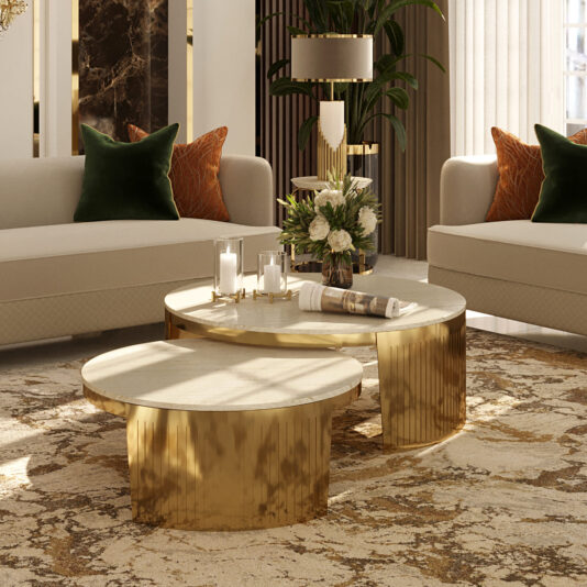 Modern Marble Set Of Coffee Tables A luxurious living room features two Modern Marble Set Of Coffee Tables on a patterned rug, surrounded by cream sofas with dark green and burnt orange cushions. The tables are adorned with a vase of flowers and candles, while warm lighting highlights the elegant decor.