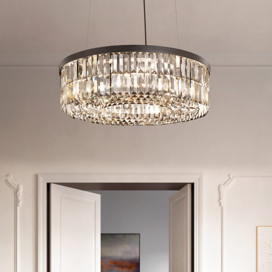 The Modern Onyx Chandelier graces the ceiling, its clear prisms sparkling with light. Above the doorway, the top of an open white door peeks beneath it against light-colored walls.