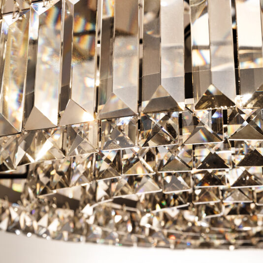 Modern Smoked Cut Crystal Chandelier A close-up of the Modern Smoked Cut Crystal Chandelier displays its stunning rectangular and square crystals. These gems reflect light, creating a captivating sparkle with their tiered arrangement, producing colorful reflections.