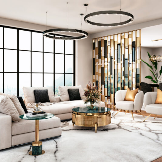 A modern living room showcases two large circular light fixtures, a sectional sofa with white cushions, a Round Modern Marble Coffee Table with gold accents, and a gold-accented mirrored wall. Large windows flood the space with natural light, complemented by plants and pillows.
