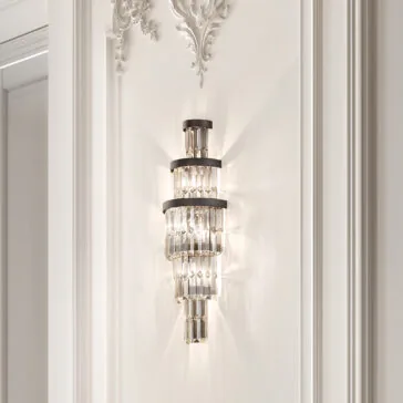 Smoked Cut Crystal Tiered Wall Light The Smoked Cut Crystal Tiered Wall Light adorns the ornate white wall, its luxurious crystal accents casting a soft, elegant glow that enhances the decorative molding.