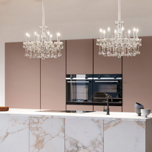 A modern kitchen with a marble island, built-in appliances, matte pink cabinets, and two Classic Style Crystal Chandeliers above the island. A black faucet and bowls complete the elegant countertop design.