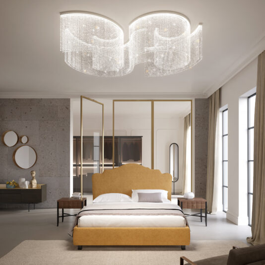 A luxurious bedroom features a large golden bed with white linens and wooden nightstands. The eye-catching centerpiece is the Large Statement Cut Crystal Ceiling Light. Mirrors and decor adorn the walls, while expansive windows let in natural light.