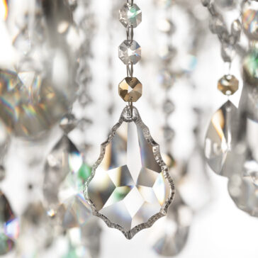Double Crystal Wall Light A close-up of the Oval Crystal Ceiling Light (Copy) highlights a teardrop crystal reflecting rainbow light, while other blurred crystals in the background create a sparkling, elegant atmosphere.