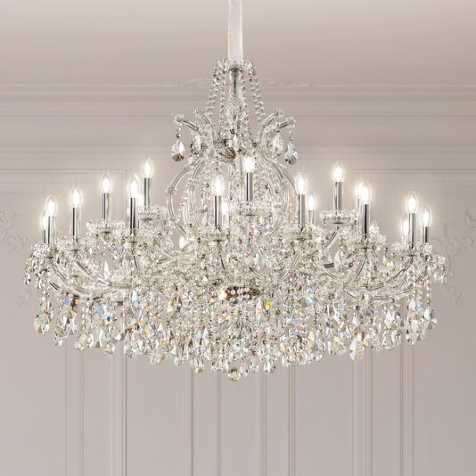 The Classic Style Tiered Crystal Chandelier (Copy) features multiple candle-style bulbs and sparkling hanging crystals, elegantly suspended from a white ceiling in a bright, ornate room.