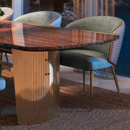 A contemporary dining room showcases the Contemporary Oval Glass Dining Set with a polished surface and gold metallic base. Stylish gray and white upholstered chairs with metallic legs surround it, creating a warmly lit ambiance ideal for intimate gatherings.