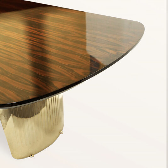 A close-up of the Large Modern Veneered Dining Set showcases a glossy wooden top with a reflective surface. Its distinctive ridged metallic pedestal base exudes elegance and sophistication against a plain white background.