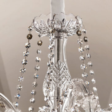 Ornate Crystal Chandelier Close-up of the Ornate Crystal Chandelier, highlighting its intricate glasswork and strands of faceted crystal beads that reflect light for a dazzling, sparkling effect.