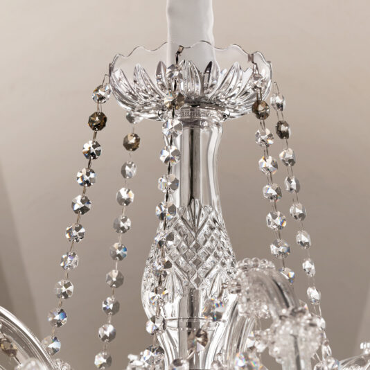 Close-up of the Ornate Crystal Chandelier, highlighting its intricate glasswork and strands of faceted crystal beads that reflect light for a dazzling, sparkling effect.