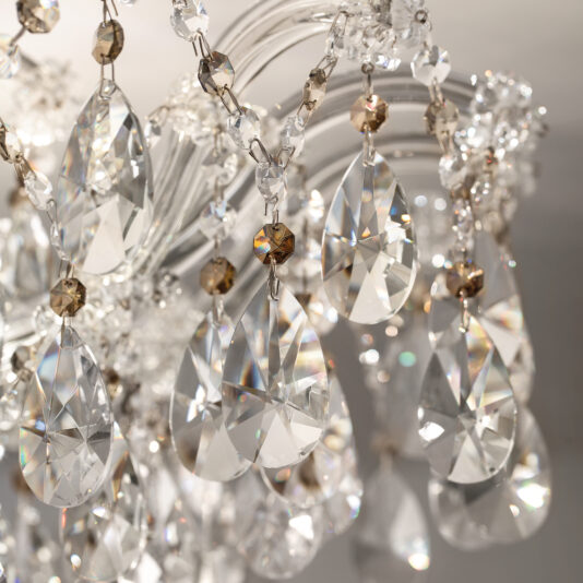 Close-up of the Round Crystal Ceiling Light shows sparkling prisms and faceted beads reflecting light, with teardrop crystals creating rainbow effects for a luxurious, elegant atmosphere.