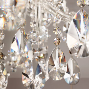 Close-up of sparkling teardrop and faceted pendants on the Classic Style Empire Crystal Chandelier, reflecting light and casting colorful prismatic patterns.