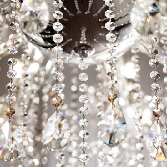 Classic Style Empire Crystal Chandelier Close-up of sparkling crystal beads and teardrop pendants on the Classic Style Empire Crystal Chandelier, reflecting light into vibrant, prismatic colors.