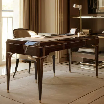 Exclusive Designer Writing Desk The Exclusive Designer Writing Desk stands on a light rug near a sunlit window in a sophisticated, well-organized room, paired with a matching chair, lamp, notebooks, and a framed photo.