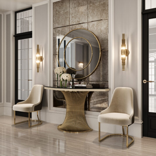 Modern Lacquered Demi Console Elegant foyer with two cream chairs flanking a Marble Demi Console (Copy), topped with white flowers and books. A large, round gold-framed mirror hangs above, accented by wall sconces and paneled walls for a sophisticated touch.