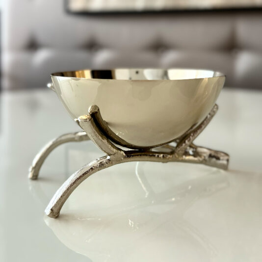 The Nut Bowl On Branch Design features an artistic metallic silver stand, displayed on a reflective white surface with a blurred background.