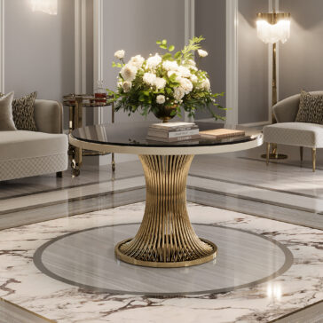 The Round Marble Contemporary Dining Table (Copy) with a gold sculptural base is featured in a luxurious room, topped with white flowers and books, surrounded by elegant sofas and marble flooring.