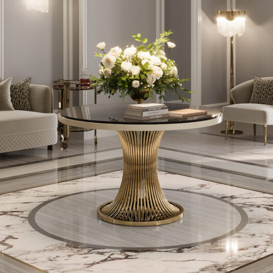 The Round Marble Contemporary Dining Table (Copy) with a gold sculptural base is featured in a luxurious room, topped with white flowers and books, surrounded by elegant sofas and marble flooring.
