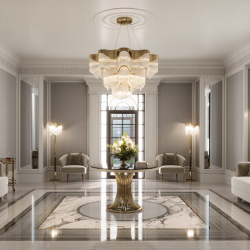 The elegant lobby features a Round Marble Contemporary Dining Table (Copy) as the centerpiece with florals, surrounded by two armchairs, tall standing lamps, and a large chandelier. Light pours in through a tall arched window in the background.