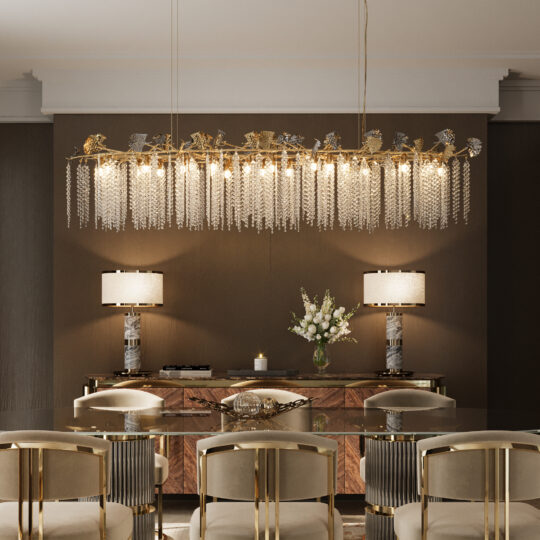 An elegant dining room features a glass table, gold-accented chairs, and the Contemporary Leaf Chandelier With Crystal Drops. Matching lamps on a wooden sideboard and a vase of white flowers complete the neutral, sophisticated décor.