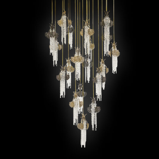 Pendant lights shaped like moths with intricate golden wings and crystal bead bodies, suspended at varying heights against a black background, reflect the elegance of the Large Leaf Chandelier With Crystal Drops (Copy).