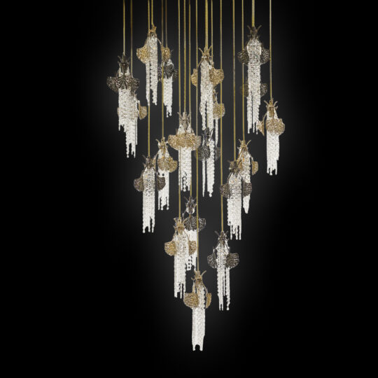 Pendant lights shaped like moths with intricate golden wings and crystal bead bodies, suspended at varying heights against a black background, reflect the elegance of the Large Leaf Chandelier With Crystal Drops (Copy).