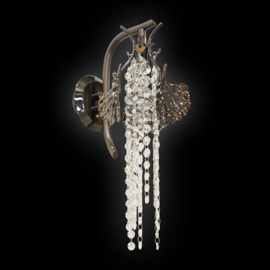 The Leaf Wall Light With Crystal Drops features a dark metallic base, ornate leaf accents, and hanging clear crystal beads, all set against a black background.