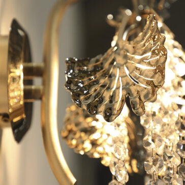Leaf Wall Light With Crystal Drops The Leaf Wall Light With Crystal Drops features ornate golden leaf decorations and hanging clear beads, warmly illuminated to add an elegant, luxurious touch to your space.