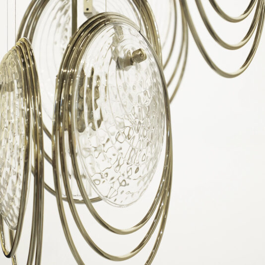 Close-up of the Modern Round Chandelier Inspired By The Sea (Copy), showcasing textured glass discs and concentric metal rings against a plain white background.