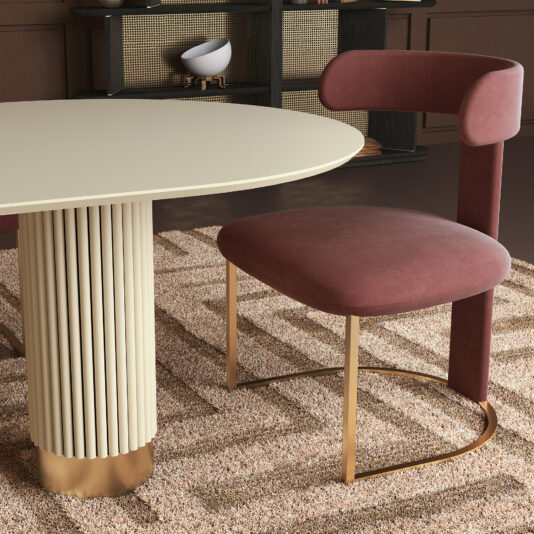 Modern T Backed Dining Chair The Modern Dining Chair (Copy) features pink upholstery and gold legs, paired with a round, cream-colored table with fluted detailing on a textured beige rugāa stylish addition to any dining room.