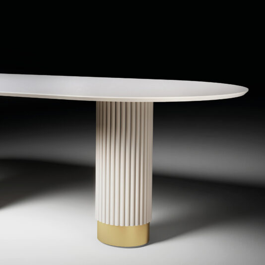 Oval Contemporary Lacquered Dining Table The Round Contemporary Lacquered Dining Table (Copy) showcases a white oval top and a fluted cylindrical base with a gold-colored bottom, presented against a dark gradient background.