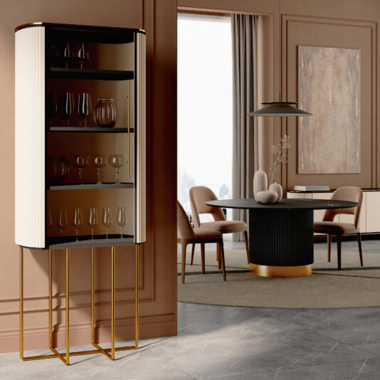 A modern dining room features the Contemporary Lacquered Cabinet (Copy) displaying glassware, a round dining table with sculptural decor, upholstered chairs, large wall art, and floor-to-ceiling curtains.