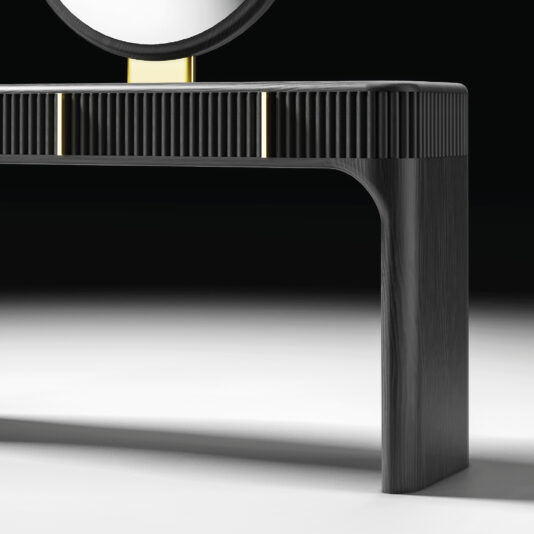 Contemporary Veneered Dressing Table The Contemporary Lacquered Dressing Table features black lacquer, gold accents, rounded edges, a ribbed texture, and a circular mirror. It is shown against a dark background on a white surface.