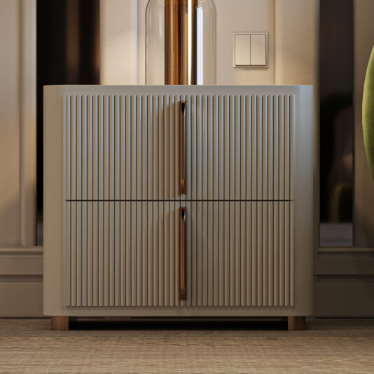 The Contemporary Ribbed Lacquered Bedside Cabinet, featuring vertical grooves and slim wooden handles, is set against a neutral wall beside a green chair on a carpeted floor in a softly lit room.