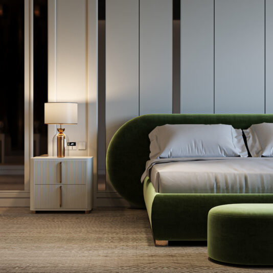 A modern bedroom features a green velvet bed, white bedding, and a matching green ottoman. The Contemporary Ribbed Lacquered Bedside Cabinet with a gold lamp enhances the minimalist decor with an elegant touch and soft lighting.