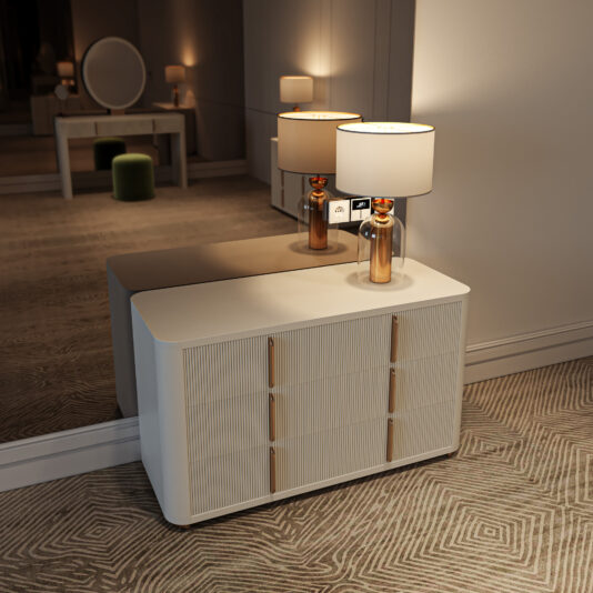 Contemporary Ribbed Lacquered Dresser The Contemporary Ribbed Lacquered Bedside Cabinet (Copy) with gold handles stands before a large mirror, topped with a gold lamp and white shade that softly reflects in the gentle lighting of the carpeted room.