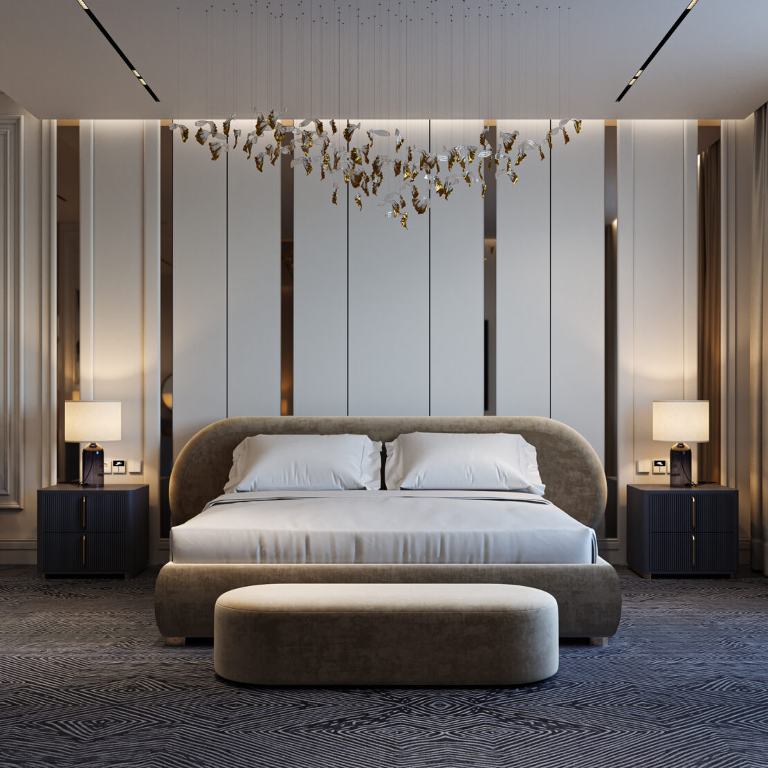 A modern bedroom features a large bed with pillows, a rounded headboard, matching bench, minimalist wall panels, and Modern Ribbed Lacquered Bedside Drawers (Copy) with lamps on each side. A sculptural light fixture hangs overhead.