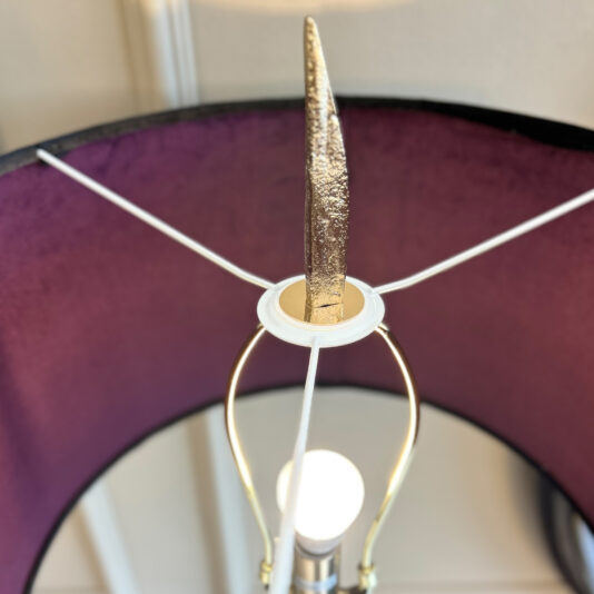 A top-down view of the Large Abstract Table Lamp With Velvet Shade shows a gold finial, white harp, and visible bulb and neck inside the velvet shade with a dark purple interior lining.