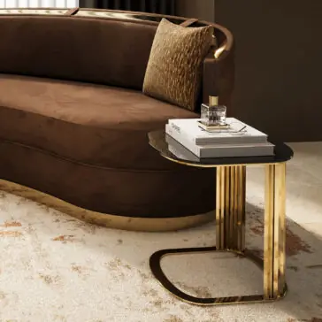 Modern Art Deco Inspired Side Table A modern living room featuring a curved brown sofa, a patterned pillow, and the Modern Art Deco Inspired Side Table displaying books, a candle, and a reed diffuser on a light patterned rug.