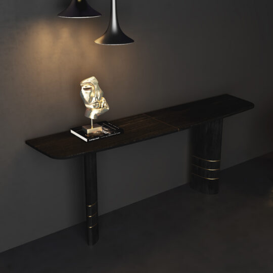 A Wall Mounted Contemporary Console Table with gold accents stands against a gray wall, displaying a decorative gold sculpture and black book. Nearby, a Contemporary Round Glass Dining Table adds modern flair beneath pendant lights.