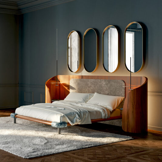 Contemporary Pill Wall Mirror A modern bedroom with a wooden bed, white bedding, and light gray headboard features the Contemporary Geometric Chaise Longue beside a fluffy white rug. Four oval mirrors above reflect light onto muted blue-gray walls.