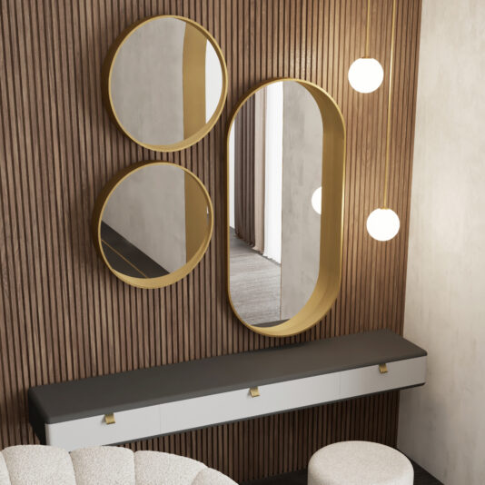 Contemporary Pill Wall Mirror A modern vanity area features two round and one oval Contemporary Pill Wall Mirrors with gold frames on a wood-panelled wall, globe pendant lights, a long shelf with drawers, a round upholstered stool, and a geometric chaise longue for style.