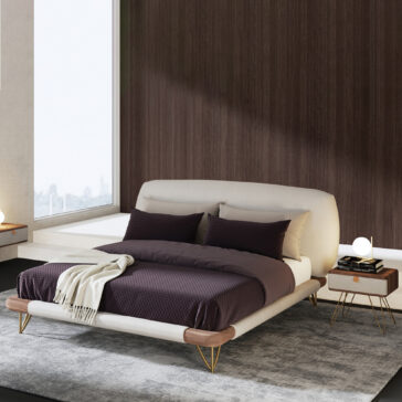 Contemporary Veneered Bedside Cabinet A modern bedroom includes a low-profile bed with a cream frame, dark bedding, and two Contemporary Veneered Bedside Cabinets topped with lamps. A soft grey rug lies on the floor, and large windows fill the room with natural light.